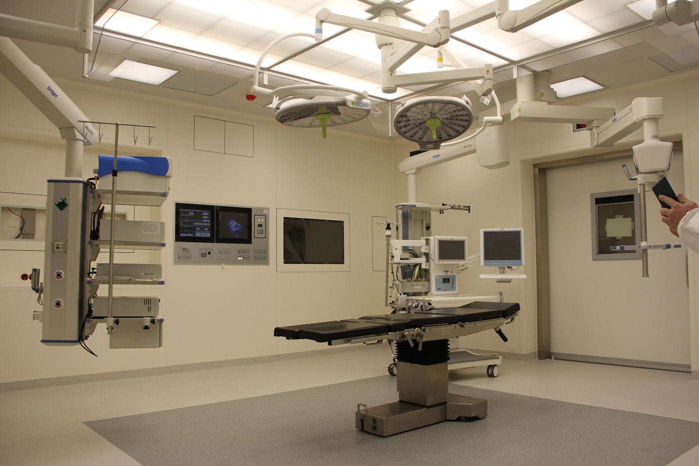 Salle d'opération hospitalière avec moniteurs et équipements connectés représentant les systèmes cliniques auxquels le logiciel de santé doit s'intégrer