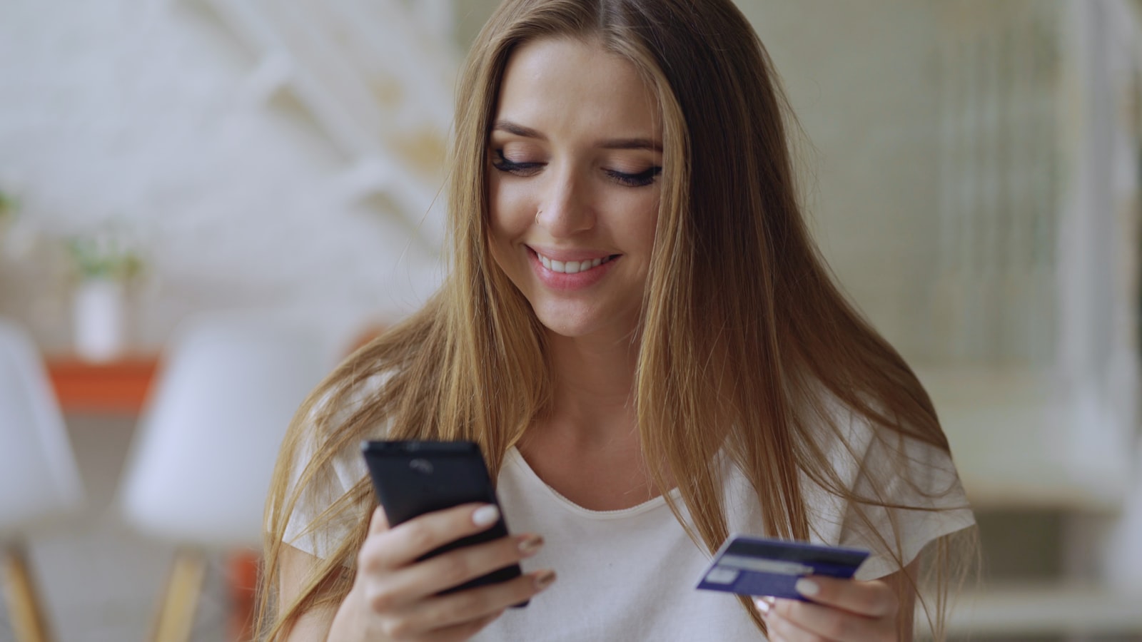 A buyer shopping on a phone with a credit card in hand — the demand side a marketplace must win in parallel with supply