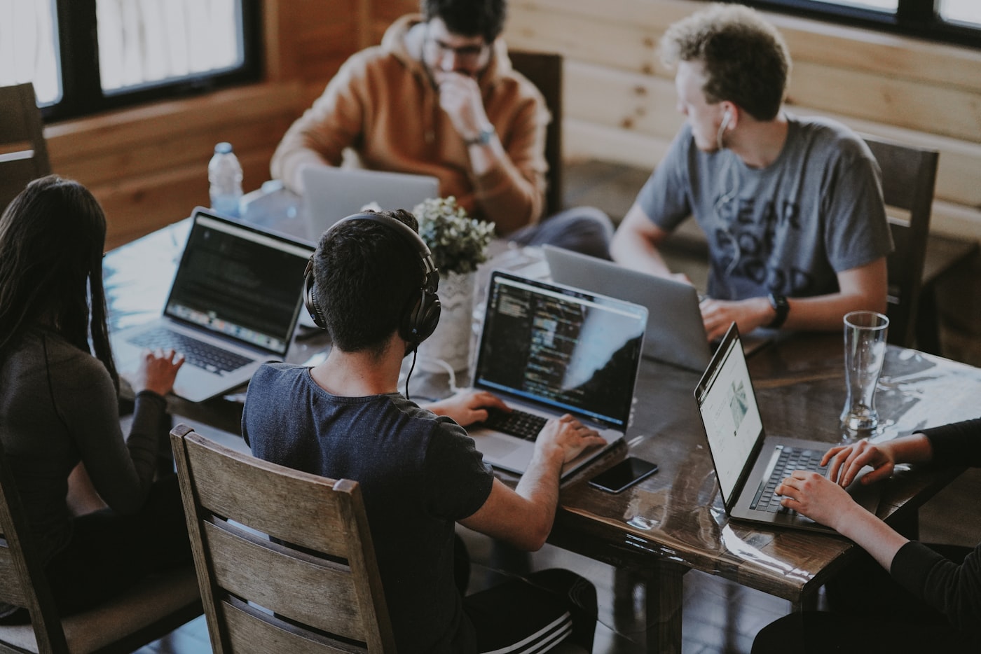 Mobile development team collaborating around a table with laptops
