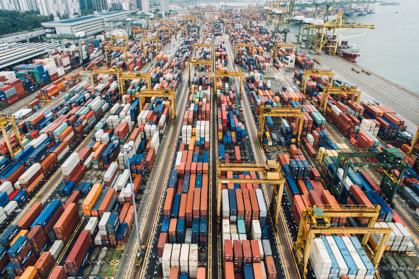 Aerial view of a container port with cranes and stacked containers — carrier network and multimodal freight integration