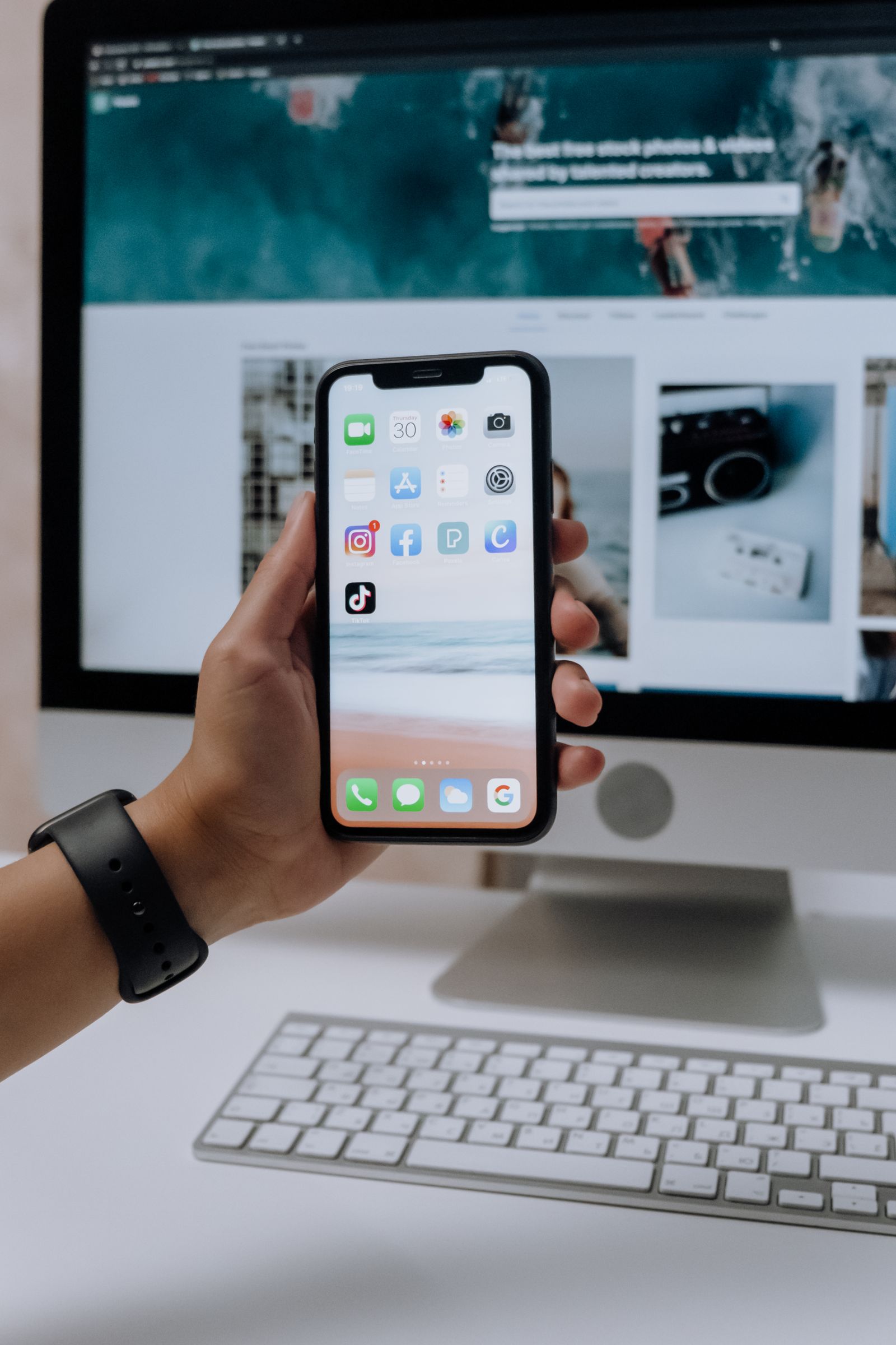 Sviluppatore che crea una Progressive Web App su un laptop con uno smartphone che mostra l'icona PWA installata sulla schermata Home