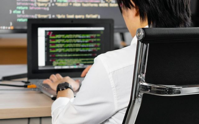 Experienced engineer working with code on a multi-monitor setup