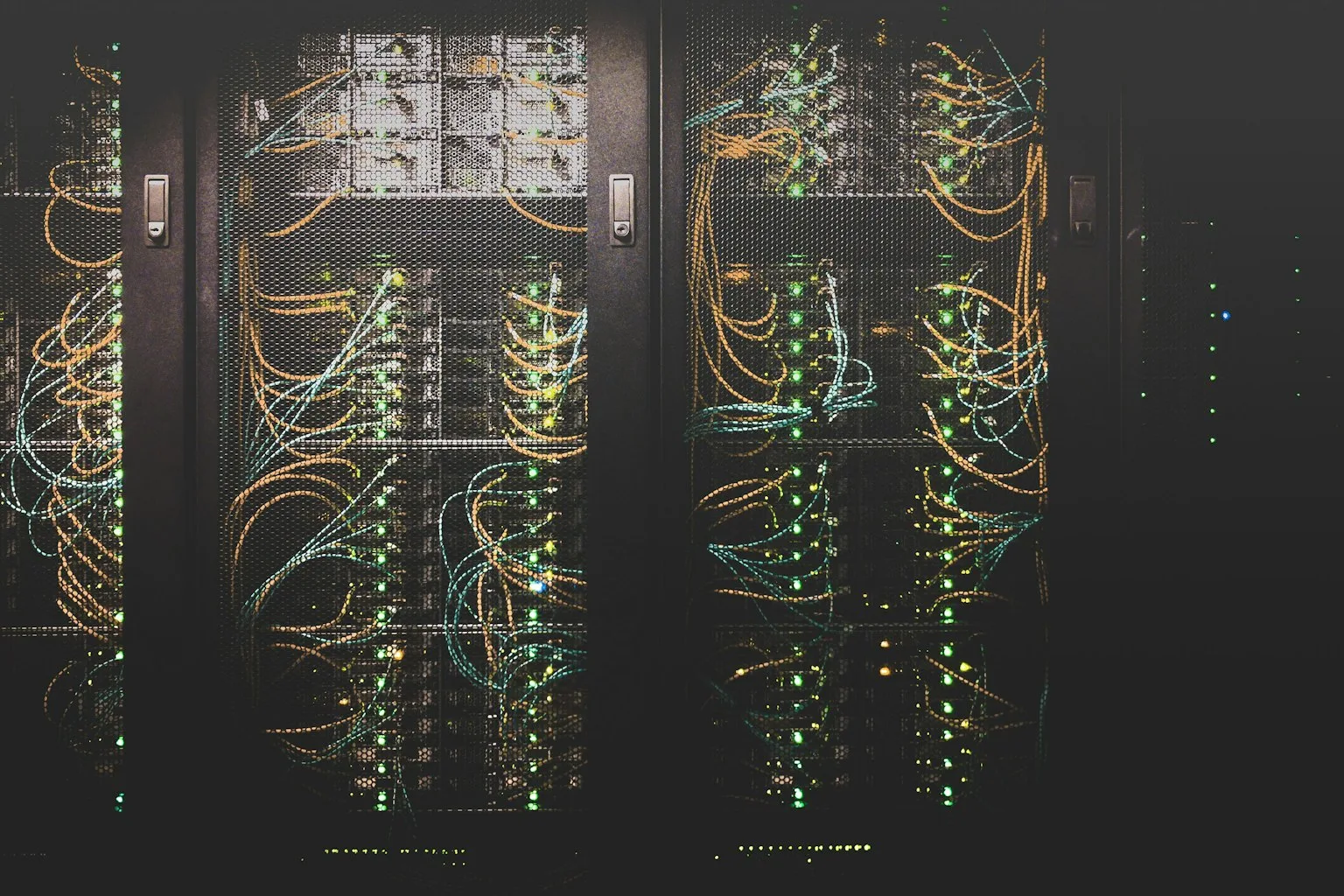 High-density server racks with colorful networking cables and LED status lights in a modern enterprise data center
